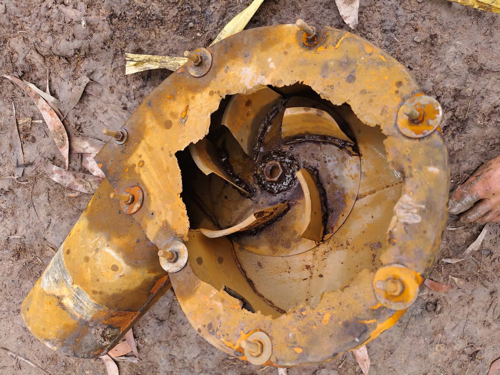 Close-up of a pump head heavily corroded by acid water